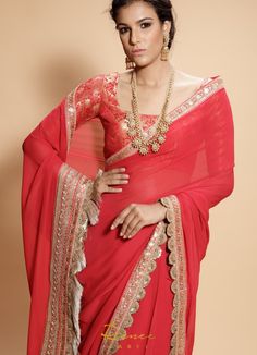 This set features a wide neck neck blouse tailored in rose red and gold brocade. It is teamed with a matching georgette sari with scallop, zari and dori borders and gold tassels at the palla. Includes Satin Underskirt Composition: Blouse: Brocade Silk, Sari : Viscose Georgette All products can be customised for sleeves, length of blouse and neck design Delivery : 2 weeks as the product is hand crafted. Check Size Guide or choose MySize for free customisation (All Sizes above XL can be made at 15 Brocade Blouse, Latest Dress Design, Brocade Blouses, Gold Brocade, Indian Wedding Wear, Party Wear Lehenga, Red Saree, Stylish Sarees, Fancy Sarees