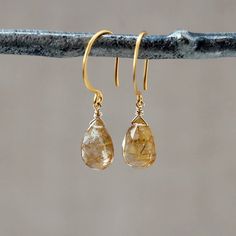 Sparkly and gorgeous, teardrops of Golden Rutilated Quartz hang simply from 24k gold vermeil ear wires. These are lightweight earrings that will wear easily. Golden Rutilated Quartz, also known as Angel's Hair Quartz, is a clear quartz with fine, gold needles or strands of inclusion visible inside. These needles or "rutiles" are minerals containing titanium oxide. It's a truly eye-catching stone that is thought to help the wearer increase mental clarity and aid in decision making.{ The earrings Gold Teardrop Gemstone Earrings, Yellow Gold Gemstone Teardrop Earrings, Wire Wrapped Teardrop Earrings For Anniversary, Yellow Gold Teardrop Dangle Earrings With Gemstone, Teardrop Earrings With Natural Inclusions, Rutilated Quartz Jewelry, Textured Gold Ring, Golden Rutilated Quartz, Hammered Rings