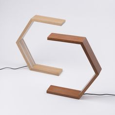 a wooden table lamp sitting on top of a white floor next to a charger