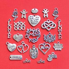 a bunch of charms that are on a red tablecloth with the word love written in it