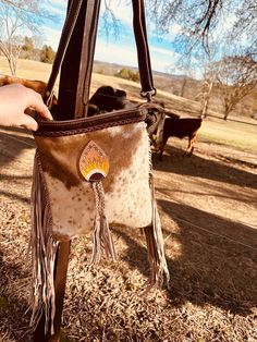 Hair on cowhide side bag Tooled sunflower detail Fringe detail Bohemian Leather Bag With Concho, Bohemian Brown Bags With Concho, Western Brown Bag With Fringe, Brown Western Bag With Fringe, Country Style Brown Bag For Everyday Use, Western Style Bags With Fringe For Everyday Use, Western Style Fringe Bags For Everyday Use, Western Style Fringed Bags For Everyday Use, Tooled Sunflower