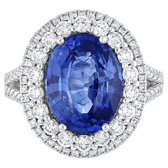 an oval shaped blue sapphire surrounded by white diamonds in a halo setting with two rows of round brilliant cut diamonds surrounding it