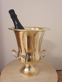 a gold vase with a bottle of wine in it