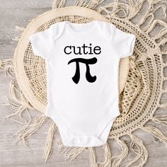 This cutie pi baby bodysuit brings out more fun on Pi Day. Crafted from 100% cotton interlock fabric, this sweet bodysuit features a reinforced three-snap closure on the binding and piped leg seams for a comfortable and snug fit. Soft and gentle on touch, it's also designed with lap shoulders for easy changing. The white color is sewn with 100% cotton thread, creating a classic heirloom look. Best of all, it's printed on a direct to garment printer with premium eco-based ink for safety and style Playful Cotton Onesie For First Birthday, Cute Cotton Onesie For Birthday, Cotton Cute Onesie For Birthday, Unisex Cute Onesie With Letter Print, Cute Unisex Cotton Onesie, Unisex Onesie With Letter Print, Cute Cotton Short Sleeve Bodysuit For Playtime, Unisex Letter Print Onesie, Cute White Short Sleeve Bodysuit