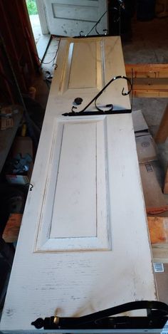 an old white door is being repaired and put in place with some tools on the floor