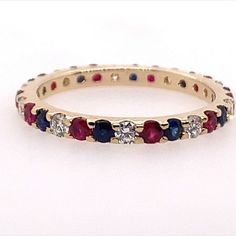 a gold ring with red, white and blue stones