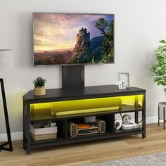 a flat screen tv sitting on top of a black entertainment center in a living room