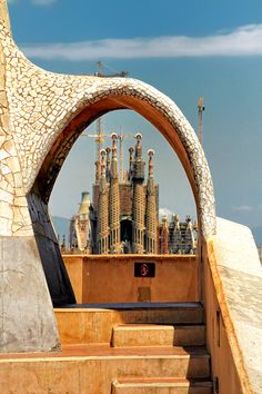 an arch leading up to a building with spires on the top and below it