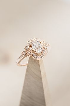 a diamond ring sitting on top of a wooden stand