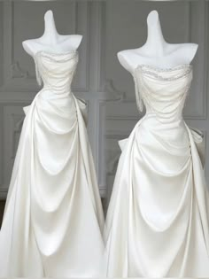 two white wedding gowns on mannequins in front of a gray wall