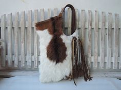 BROWN WHITE TOTE with Woven Leather Tassels Calf Hair Bag with Hand Leather Cross Weave Country South Western Cowgirl Fur Bag Shoulder bag. Introducing our Brown White Tote, a must-have accessory that seamlessly blends style and practicality. Crafted with meticulous attention to detail, this shoulder bag features woven leather tassels and calf hair, embodying the essence of South Western Cowgirl chic. Indulge in luxury with our handpicked cow hides, ensuring each piece boasts unique markings for White Rectangular Hobo Bag With Leather Handles, White Fringe Travel Bag, White Double Handle Hobo Bag With Leather Handles, Brown Tasseled Bags For Shopping, Brown Tassel Bags For Shopping, White Travel Bags With Tassels, Brown Shopping Bags With Tassels, White Tassel Travel Bags, White Tassel Shoulder Bag For Travel