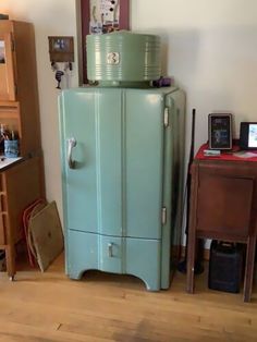 a green refrigerator sitting in the corner of a room