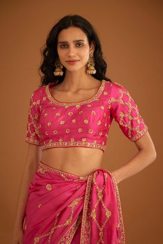 Editor's Note A fuschia pink zardozi embroidered dupion silk sari and blouse would be a stunning and bold choice for a formal occasion. The rich and luxurious fabric of the dupion silk would drape beautifully, while the intricate zardozi embroidery would add texture and depth to the overall look. Color: Pink Fabric: Dupion silk Embroidery details: Zardozi embroidery Components: Sari & blouse Sari length: 6 meters, sari width: 46" inches Occasion: Festive and Wedding Guest Disclaimer: Product col Pink Art Silk Pre-draped Saree With Intricate Embroidery, Pink Raw Silk Pre-draped Saree With Resham Embroidery, Festive Pink Pre-draped Saree With Dori Work, Pink Anarkali Style Silk Pre-draped Saree, Traditional Drape Blouse With Zari Work For Reception, Designer Pink Pre-draped Saree With Zari Work, Pink Silk Pre-draped Saree In Traditional Style, Pink Silk Choli For Parties, Pink Silk Choli For Party