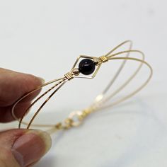 A sweet design of three strands of 14kt gold filled wire featuring a single 6mm genuine garnet bead flanked by two small 14kt gold filled beads. The garnet bead is a very deep dark red, almost black (unless you hold it up to the light or next to something that's actually black!) This stylish, well-fitting bangle will go with most everything in your closet, and is sure to get noticed every time you wear it. So delicate and feminine! The sturdy built-in hook and eye clasp is easy to get on and off Resizable Gold Wrap Bracelet As Gift, Elegant Hand Wrapped Gold Jewelry, Elegant Rose Gold Hand Wrapped Jewelry, Minimalist Gold Beaded Bracelets Hand Wrapped, Minimalist Wire Wrapped Round Bead Jewelry, Handmade Gold Bangle For Friendship, Elegant Hand Wrapped Jewelry With Round Beads, Elegant Hand Wrapped Rose Gold Bracelet, Adjustable Gold Gemstone Bracelet Gift