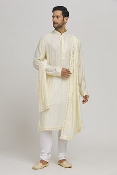 Cream kurta with thread embroidered floral patterns and sequin work embellishments. Comes with churidar and dupatta. - Aza Fashions Festive Chikankari Embroidery Straight Kurta, Navratri Dola Silk Kurta With Embroidered Border, Festive Embroidered Traditional Wear In Cotton Silk, Dola Silk Kurta With Embroidered Border For Festivals, Festive Cotton Silk Churidar With Chikankari Embroidery, Festive Chikankari Embroidered Cotton Silk Churidar, Festival Dola Silk Kurta With Embroidered Border, Designer Cotton Silk Embroidered Fabric For Diwali, Festive Chikankari Embroidered Fabric For Eid