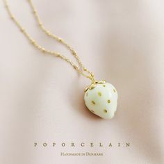 Golden White Porcelain Strawberry Necklace SKU: N_020W PRODUCT INFO How about making your summer a little fruity with this whimsical strawberry necklace? It would absolutely love to be your holiday friend. A black strawberry option is also available. MATERIAL Handmade porcelain with gold lustre Gold-plated metal SIZE & FIT Length: 28"+2"(71cm +5cm) COLOUR  White, gold WEIGHT 13g Handmade in Denmark. FREE shipping worldwide. PACKAGING All POPORCELAIN jewellery is neatly packaged with a gift box. Cute White Everyday Necklace, Cute Everyday White Necklace, Whimsical White Jewelry As Gift, Whimsical White Wedding Necklaces, Whimsical White Jewelry For Gifts, Whimsical White Necklaces For Gifts, Whimsical White Necklace For Gift, Whimsical White Necklace Perfect For Gifts, Whimsical White Pendant Jewelry