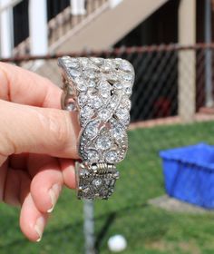 Stunning art deco style clamper bracelet! It is an intricate silver tone metal design with large rhinestone. Tiny silver metal beads surround the rhinestones and the back has a criss cross design. I love how the back also has a beautiful design and rhinestones. It is oval and hinged on the side. No makers mark. So reminiscent of the flapper era. Although this may be considered jewelry for formal wear, I think it would be so cool with jeans. It is in great vintage condition, no loss of rhinestone Glamorous Silver Cuff Bracelet With Rhinestones, Adjustable Jeweled Silver Cuff Bracelet, Formal Silver Jeweled Bracelet, Silver Jeweled Bracelet For Formal Occasions, Silver Bling Cuff Bangle Bracelet, Elegant Silver Jeweled Crystal Bracelet, Ornate Silver Jewelry With Rhinestones, Glamorous Silver Crystal Bracelet, Silver Bling Cuff Bracelet For Formal Events