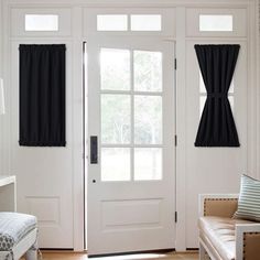 a living room with white walls and black curtains