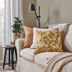 a living room with a couch, chair and lamp on it's side table