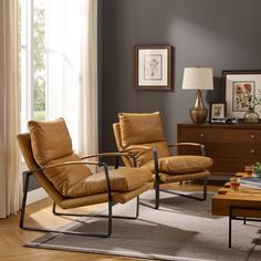 a living room with two chairs and a coffee table in front of a large window