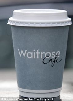 a coffee cup sitting on top of a table with the word waitrose cafe written on it