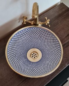 a blue and white sink sitting on top of a wooden counter next to a wall