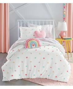 a child's bed with white sheets and pink pillows