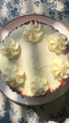 a white plate topped with a cake covered in frosting on top of a table