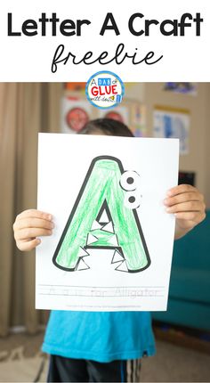 a young boy holding up a letter a craft with the words freebie on it