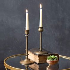 two candles sitting on top of a glass table