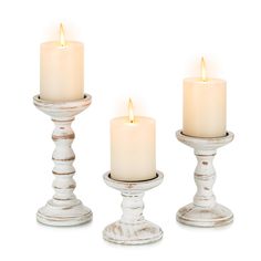 three white candles sitting next to each other