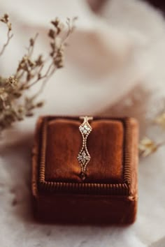 an engagement ring sitting on top of a wooden box