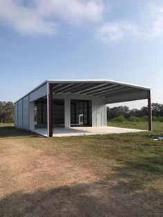 a large metal building sitting on top of a grass covered field