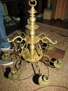 an old fashioned brass candelabra on the floor