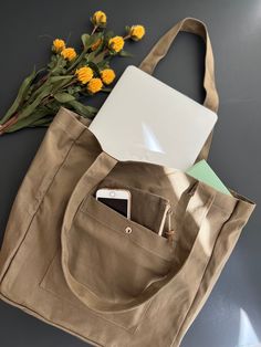 "This brown neutral tone colored tote fits everything you need for the day, on the run to school, to work, to grocery shopping, and even a relaxing weekend at a coffee shop, it got you covered. This cream tote is designed to fit MacBook pro and air, your daily journal, textbooks, and makeup pouches. This tote is designed with a large exterior pockets with a magnet button to keep your phone safe but easy access to it, and an interior pocket for your wallet. Extra seams on both sides of the bag ar Casual Laptop Bag With Large Capacity And Double Handle, Casual Large Capacity Double Handle Laptop Bag, Everyday Khaki Cotton Shoulder Bag, Khaki Tote Canvas Bag For Everyday Use, Everyday Khaki Shoulder Bag With Canvas Lining, Everyday Khaki Canvas Tote Bag, Casual Khaki Cotton Bag, Khaki Canvas Tote Bag With Pockets, Khaki Canvas Tote Bag For Everyday