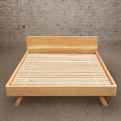 a bed with wooden slats in front of a brick wall