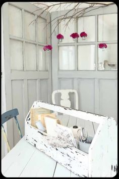 a white table topped with an old wooden box filled with items next to a window