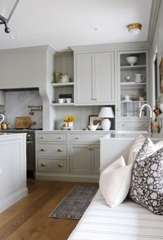 a kitchen with gray cabinets and white counter tops