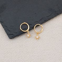 Introducing our 14K gold/ sterling silver huggie hoops with tiny celestial charm! They feature sun / starburst charm and are the perfect minimalist accessory to wear every day. The delicate and lightweight design will ensure you feel comfortable all day long. Made with high quality 925 sterling silver with 14 K gold filled finish. - Dimension:  21.5 mm x 5 mm / Huggie inner diameter: 11 mm - Hypoallergenic, Solid 925 sterling silver, Platinum or 14 K gold filled finish  - Turnaround time: Same day or Next day delivery guaranteed  - Qty: 1 pair - Packed in gift jewelry box with ribbon and wax stamp  - Please ask me any questions ! I am quick to reply :) Thank you for visiting my shop  - For shop policies, please visit: https://www.etsy.com/shop/DoodleJewelrybyDKArt Minimalist Accessories, Wax Stamp, Star Gift, Jewelry Sterling Silver, Huggie Hoop Earrings, Gift Jewelry, Jewelry Earrings Hoops, Jewelry Gift Box, Shop Policies