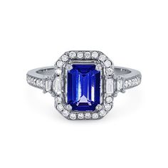 Vibrant and vintage-inspired, this ring features a 1.60 carat emerald cut tanzanite surrounded by a halo of baguette and round brilliant cut diamonds totaling 0.40 carats. Ring With Halo, Diamonds Direct, Sapphire Rings, Diamond Halo Ring, Ring Mountings, Tanzanite Ring, Halo Diamond Ring, Halo Ring, Halo Rings