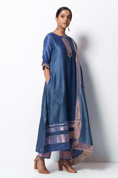 Blue handwoven kurta with zardozi floral motif embroidered placket and sleeves. Paired with cotton silk pant and stole with tassels. Comes with slip.
Component: 4
Pattern: Embroidered
Type Of Work: Floral Motifs
Neckline: Round
Sleeve Type: Elbow
Fabric: Kurta: Handwoven Chanderi Silk; Stole: Chanderi; Pant: Cotton Silk
Color: Blue
Other Details: 
Front concealed placket
Side slit kurta
Kasab thread zari tassels
Side pocketed kurta
Occasion: Puja - Aza Fashions Silk Kurta Set, Silk Pant, Silk Stoles, Blue Kurta, Silk Kurta, Cotton Set, Silk Pants, Pants Design, Floral Motifs