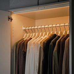 an open closet with clothes hanging on rails