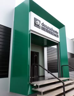 a green and white building with stairs leading up to it