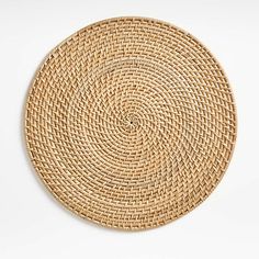 a round woven placemat on a white surface with no one in the photo looking at it