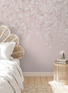 a white bed sitting next to a wall with flowers on it