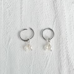 Add a touch of elegance to your everyday look with our Mini Pearl Hoop Earrings. These dainty earrings feature mini freshwater pearls and convenient click hinge earrings for easy wear. Perfect for any occasion, these cute and fun earrings are a must-have for your collection. Hoop diameter: 12mm Hoop thickness : 1.2mm Post thickness : 0.9mm Handemade with freshwater pearls, Hoop earrings are made with Sterling silver or Gold vermeil / plated over sterling silver.  Material & Care Cherished moment Dainty Earrings With Pearl Charm, Dainty White Sterling Silver Huggie Earrings, Everyday Hypoallergenic White Gold Pearl Earrings, Minimalist Dangle Huggie Earrings With Pearl Charm, Minimalist Pearl Dangle Huggie Earrings, Minimalist Huggie Pearl Earrings, Minimalist Small Hoop Pearl Earrings For Anniversary, Dainty Adjustable Hoop Earrings With Pearl Drop, Minimalist Hypoallergenic Huggie Pearl Earrings