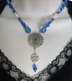 "Blue is the color of the spiritual inner self. This beautiful necklace has blue faceted beads, pearl beads, seed beads, sterling silver plated filigree beads, sterling silver plated bead caps, pewter silver pentacle and pewter silver filigree pendant. 18\" long. Toggle clasp." Mystical Blue Pendant Necklace, Handmade Gothic Blue Necklace, Handmade Blue Gothic Necklace, Mystical Handmade Blue Necklaces, Mystical Blue Jewelry For Festivals, Mystical Handmade Blue Necklace, Handmade Mystical Blue Necklace, Goddess Witchcraft, Witch Goddess