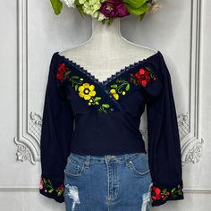 Beautiful and Chic. Our Off Shoulder tie knot blouse is sure to make a statement. One-Size elastic waist top with embroidered V-Neck and cuff sleeves. Made of 100% Cotton and embroidered in silk thread. Item available in a One-Size only. Fits Small to Medium US sizes. Elastic on shoulders and back for a secure fit. Complete the look with our handmade earrings , leather wedges and hat CARE: • Hand wash in cold water. • Hang dry.• Do not machine dry. Each design and color is unique to each blouse Mexican Tops, Traditional V-neck Spring Blouse, Spring Peasant Top With Embroidered Sleeves, V-neck Top With Embroidered Sleeves For Spring, Spring Long Sleeve Embroidered Top, V-neck Blouse With Multicolor Embroidery For Spring, Spring V-neck Blouse With Embroidered Sleeves, Casual Summer Tops With Embroidered Cuffs, Traditional V-neck Top With Floral Embroidery