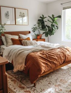 a bed sitting in a bedroom next to a window with potted plants on it