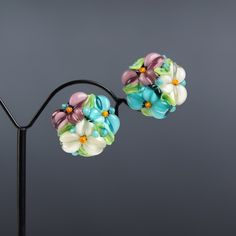 These turquoise flower earrings are made of glass in lampwork technique. The earrings posts are made of sterling silver and are hypoallergenic. 💕 You will definitely receive lots of compliments on your new earrings, everybody loves them, and you'll love them too! Dimensions: about 3/4 inch (19-21 mm) in diameter, see last photo for exact dimensions. Materials: artist lampwork glass beads, sterling silver posts. For your information: ✦ Get free shipping when you buy any two or more items! ✦ All Turquoise Nickel Free Flower Earrings, Nickel Free Turquoise Flower Earrings, Handmade Turquoise Flower Earrings, Turquoise Earrings With Flower Charm, Turquoise Czech Glass Flower Earrings For Gift, White Flower-shaped Earrings With Colorful Beads, Czech Glass Flower Earrings With Flower Charm, Artistic Multicolor Flower Drop Earrings, Green Czech Glass Flower Earrings